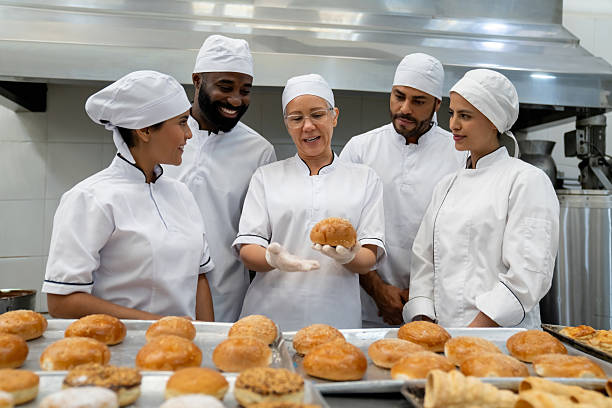 Baker training a group of new employees at a food processing plant