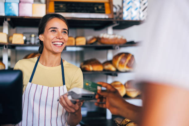 Smiling baker assisting customer in cozy artisan bakery